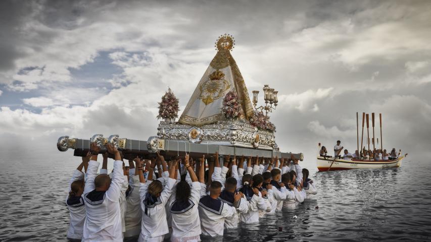 Imagen de Julio del Calendario 2026 (Juanjo Fernández) con una instantánea de la procesión de la Virgen del Carmen sostenida por los marineros