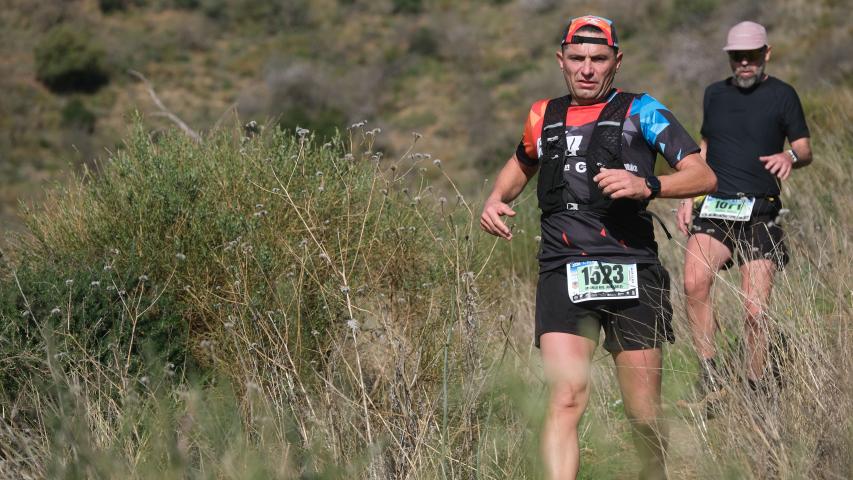 Un participante baja trotando uno de los montes del recorrido, con otra persona a su espalda, durante el XII Trail Desafío La Capitana